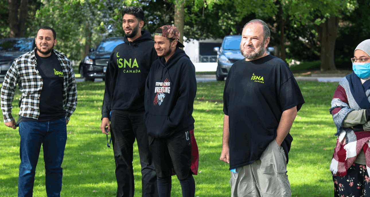 A group of Muslim volunteers outside in the park