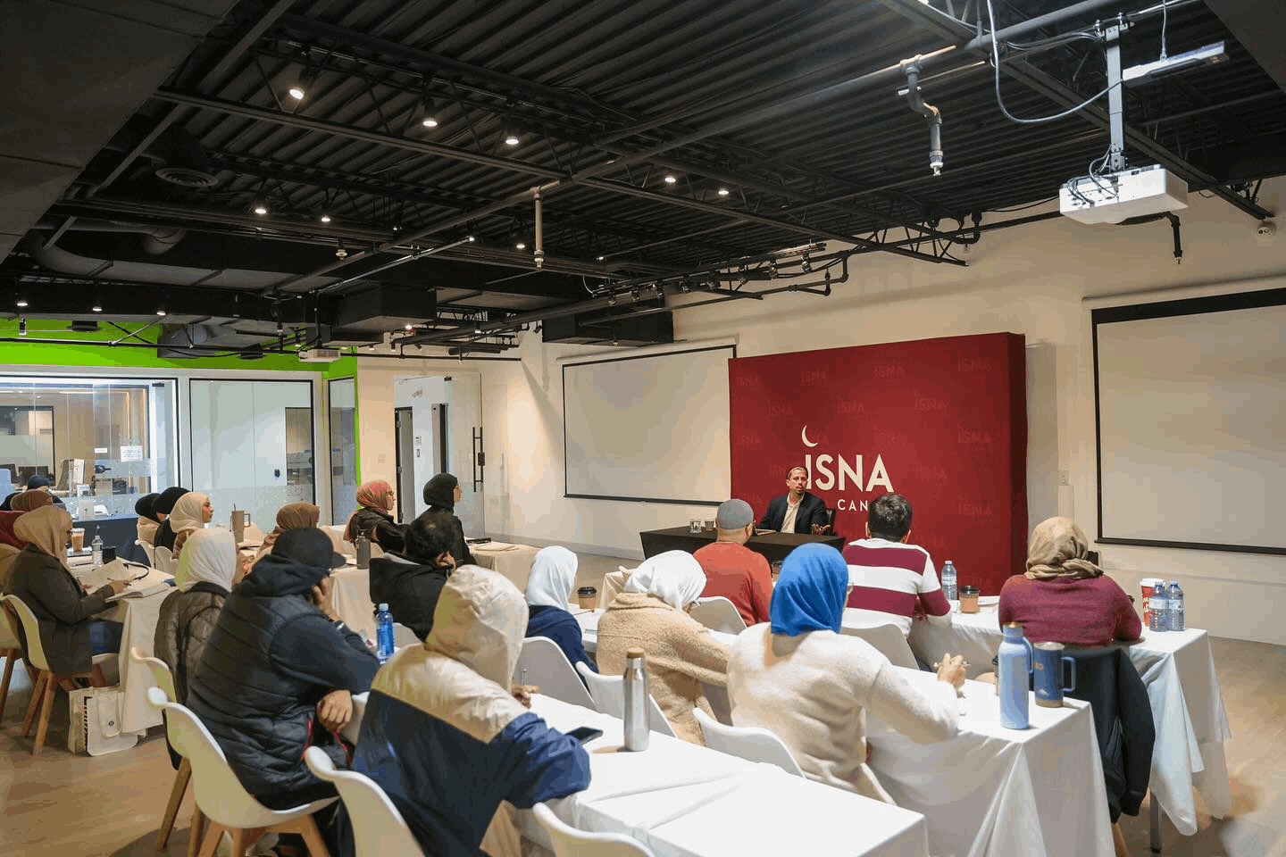 A speaker talking to a group of Muslims at an ISNA Canada event