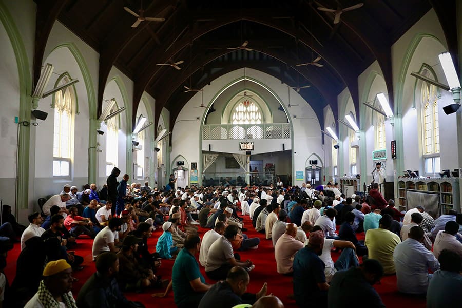 Muslims sitting together inside Jami Masjid for prayers